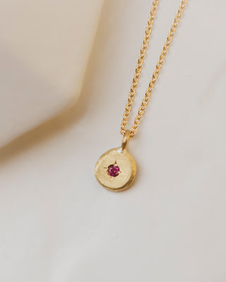 18K yellow gold pebble gemstone necklace with a ruby in the center. 5mm round with 2mm gemstone