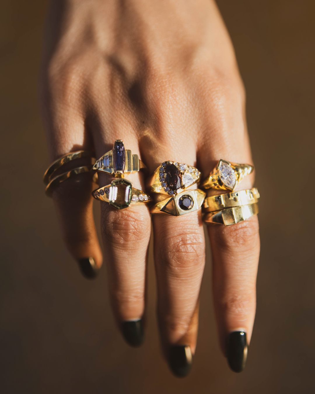 hand with gold sapphire and diamond rings
