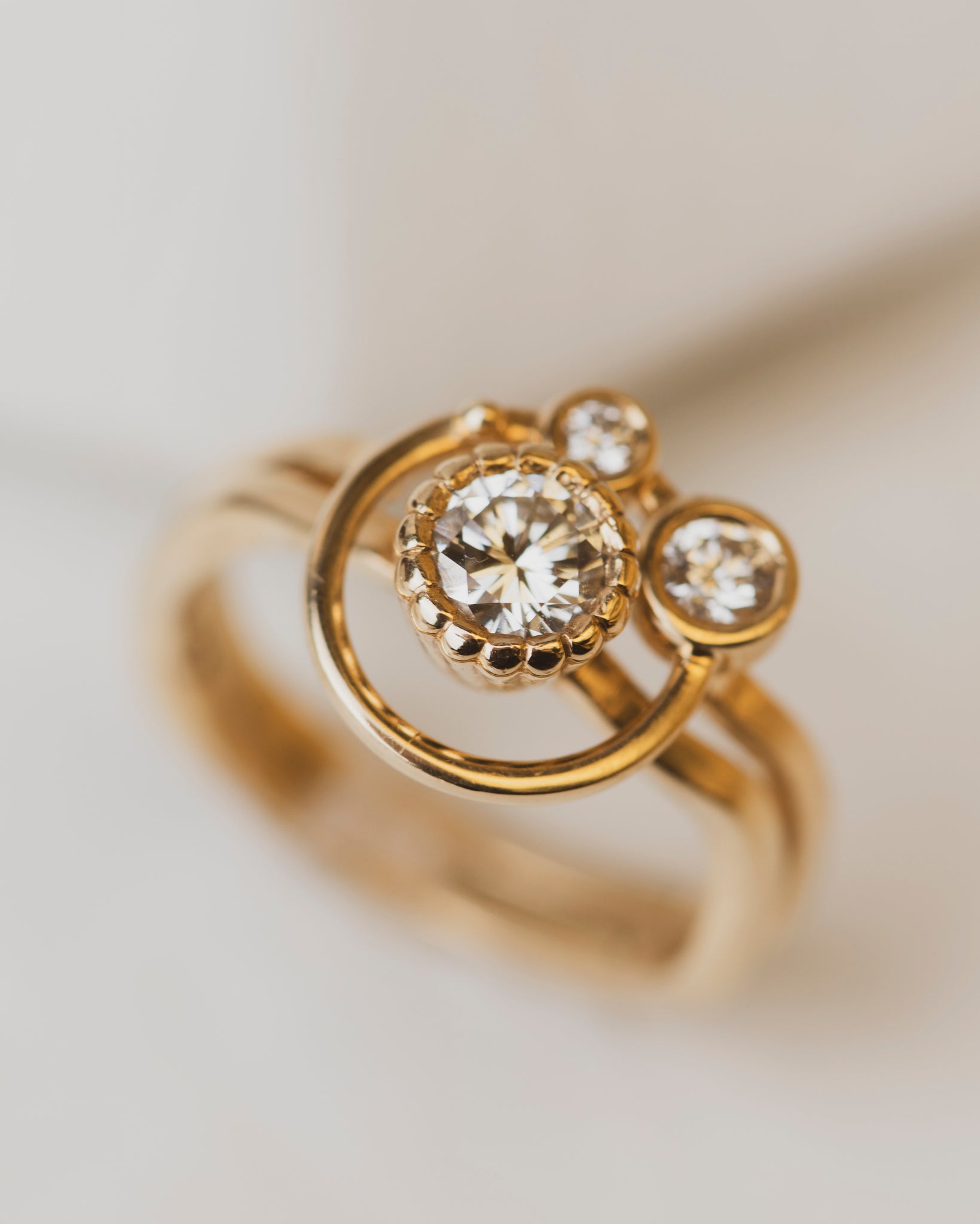 0.46 carat Bezel-set white diamond ring with accent diamond orbit band