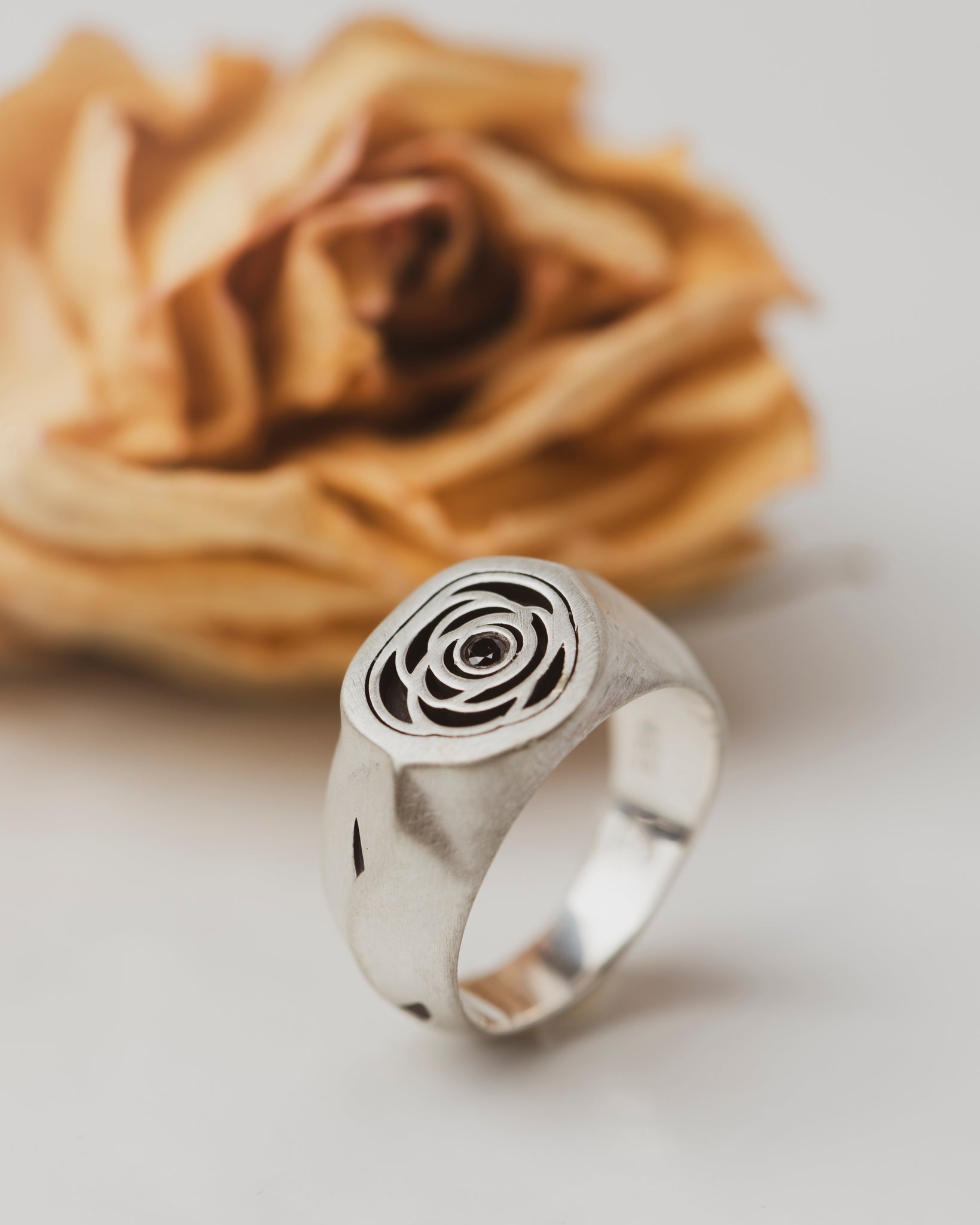 Rose Signet Ring with a Black Diamond center. The band has asymmetric shaping, giving it an organic feel. It even has thorns--where portions of the metal have been carved and oxidized.