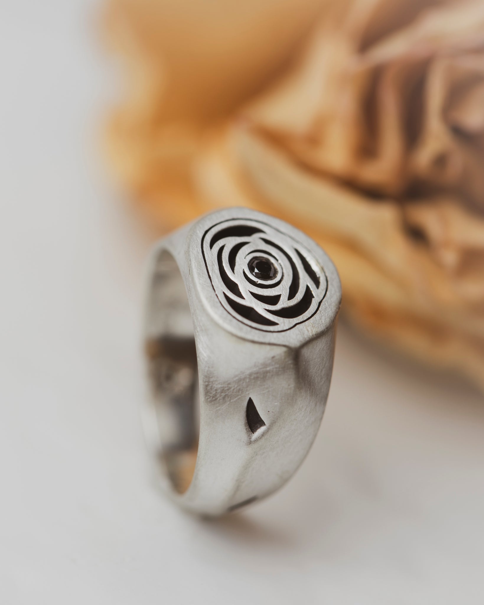 Rose Signet Ring with a Black Diamond center. The band has asymmetric shaping, giving it an organic feel. It even has thorns--where portions of the metal have been carved and oxidized.