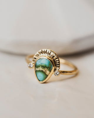 Sonoran Gold Turquoise is bezel set between two 2mm white diamonds on a shield of 18K yellow gold